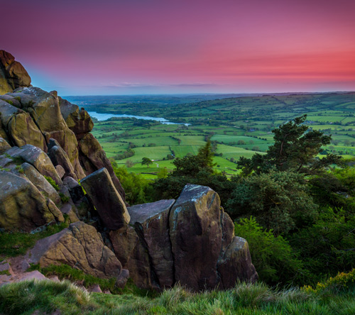 scenic landscape with rocky cliffs lush green fields and tranquil river during sunset three nature beauty